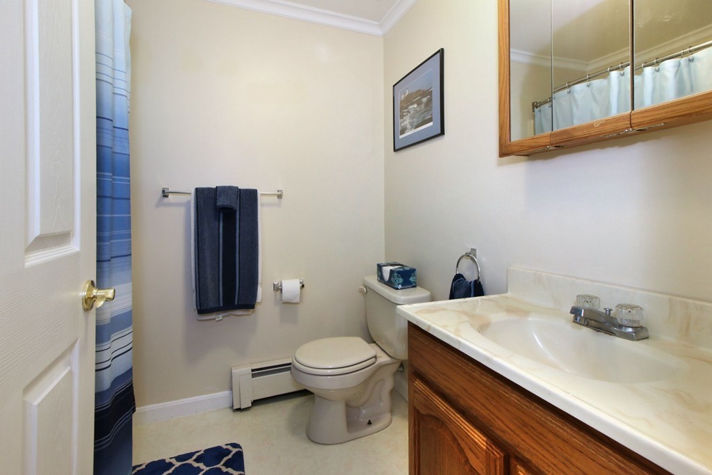90 Roper Street, Unit D Lowell, MA 01852 - Photo 11 of 17 a white toilet sitting next to a bathroom sink
