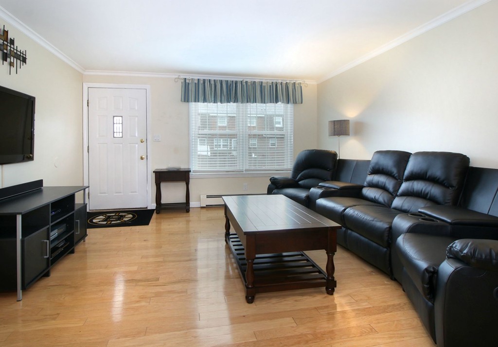 90 Roper Street, Unit D Lowell, MA 01852 - Photo 3 of 17 a living room with furniture and a flat screen tv