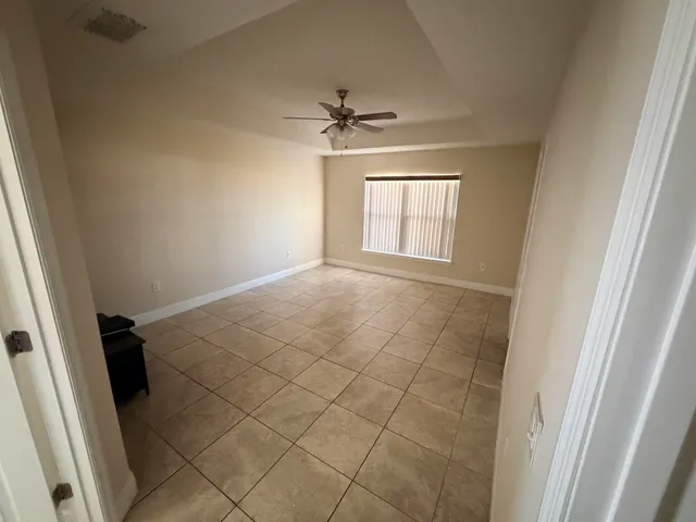 an empty room with windows and fan