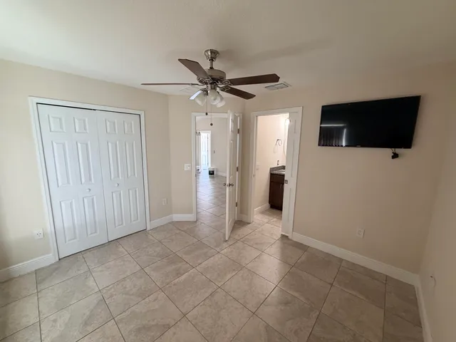 a view of a livingroom with a chandelier fan and refrigerator