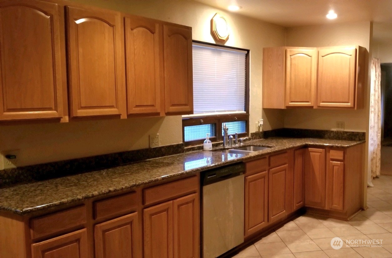 976 Ocean Beach Road Hoquiam, WA 98550 - Photo 5 of 34 a kitchen with stainless steel appliances granite countertop a sink and a wooden cabinets