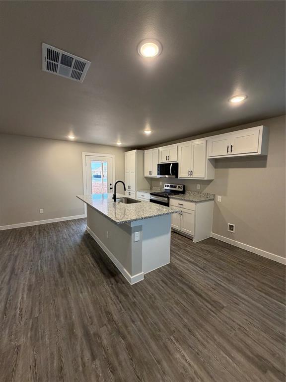 527 Colorado Street Abilene, TX 79601 - Photo 9 of 20 a large kitchen with stainless steel appliances a large counter top a stove a sink and a refrigerator