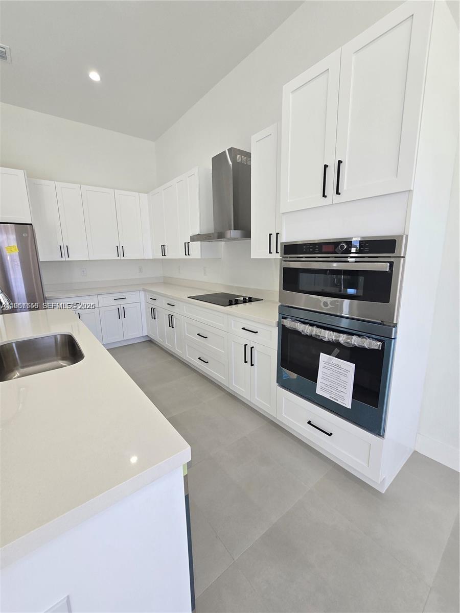 19534 Southwest 324th Street Homestead, FL 33030 - Photo 47 of 86 a kitchen with granite countertop a sink a stove and cabinets