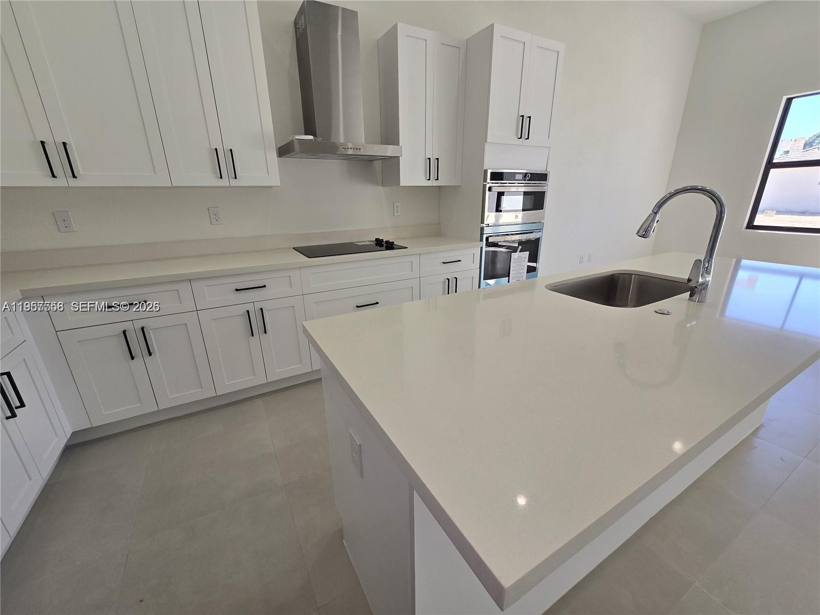 19534 Southwest 324th Street Homestead, FL 33030 - Photo 7 of 86 a kitchen with stainless steel appliances granite countertop a sink a stove and white cabinets