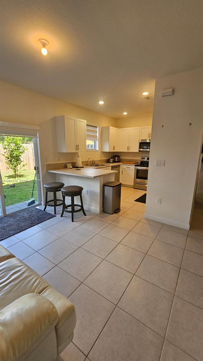 1146 Southeast 26th Street Homestead, FL 33035 - Photo 12 of 42 a kitchen with a sink and a stove top oven