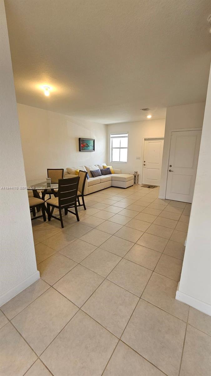 1146 Southeast 26th Street Homestead, FL 33035 - Photo 14 of 42 a living room with furniture a flat screen tv and a table