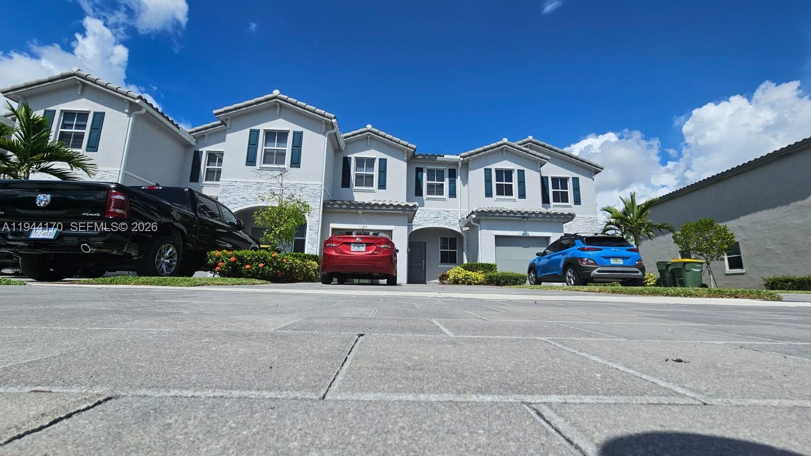 1146 Southeast 26th Street Homestead, FL 33035 - Photo 2 of 42 a front view of a house with a yard and parking