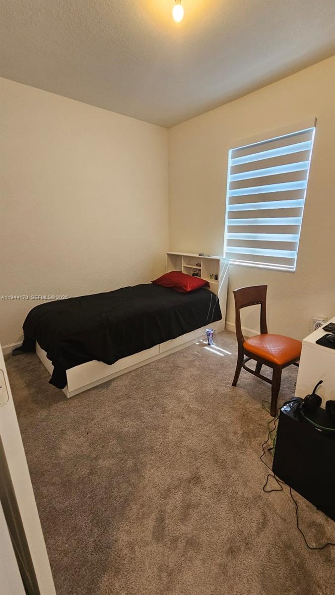 1146 Southeast 26th Street Homestead, FL 33035 - Photo 26 of 42 a bed sitting in a bedroom and chair