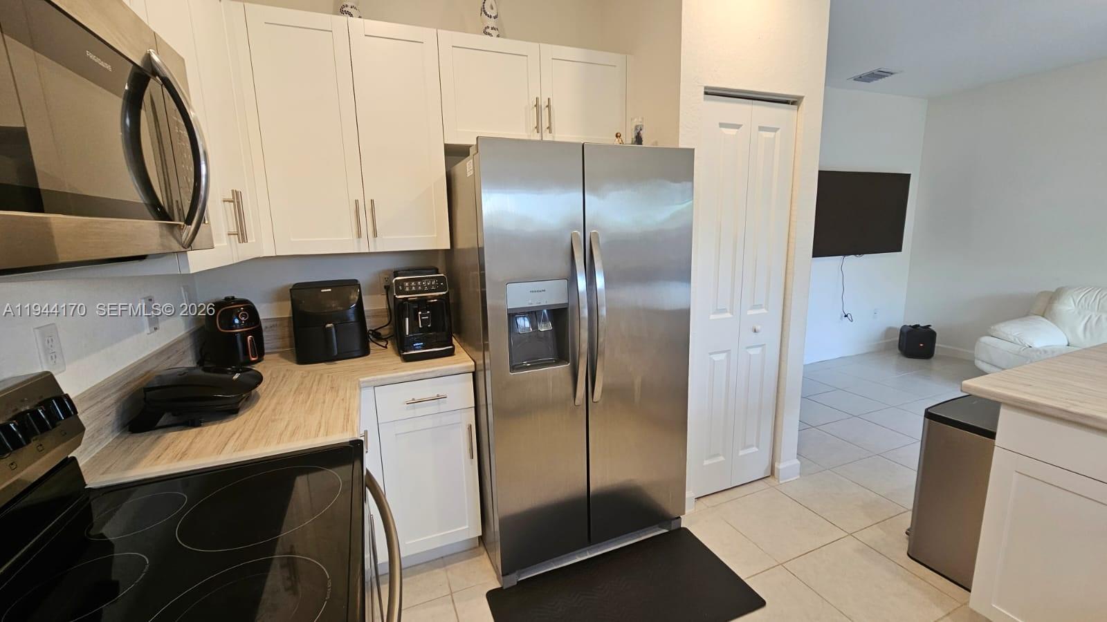 1146 Southeast 26th Street Homestead, FL 33035 - Photo 4 of 42 a kitchen with a refrigerator a stove a sink and cabinets