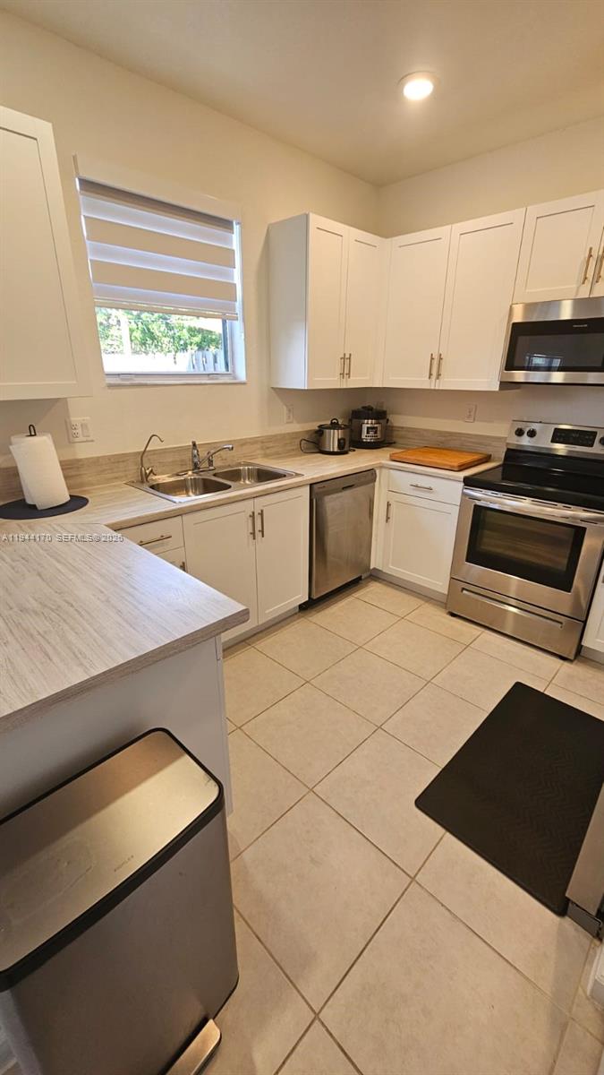1146 Southeast 26th Street Homestead, FL 33035 - Photo 6 of 42 a kitchen with a stove a sink and a microwave