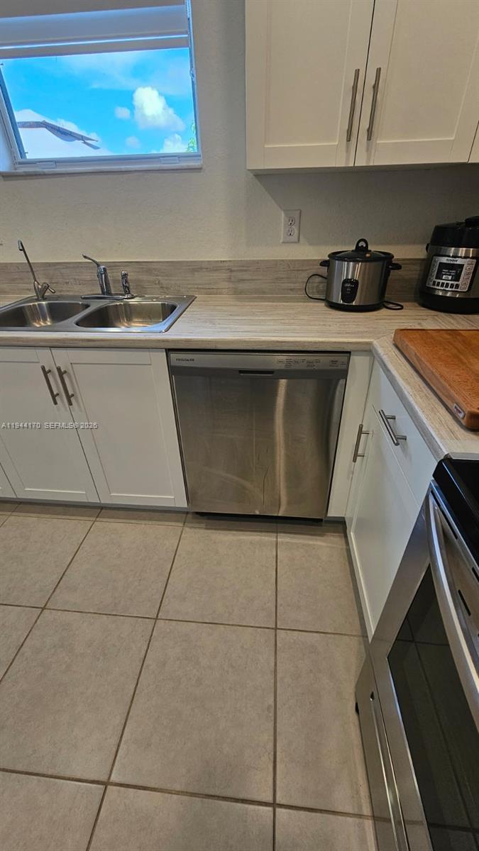 1146 Southeast 26th Street Homestead, FL 33035 - Photo 7 of 42 a kitchen with a sink a stove top oven and cabinets