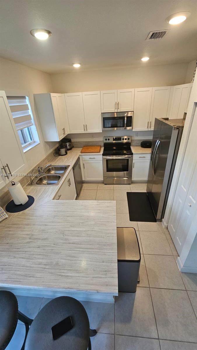 1146 Southeast 26th Street Homestead, FL 33035 - Photo 9 of 42 a kitchen with stainless steel appliances wooden floor dining table and chairs