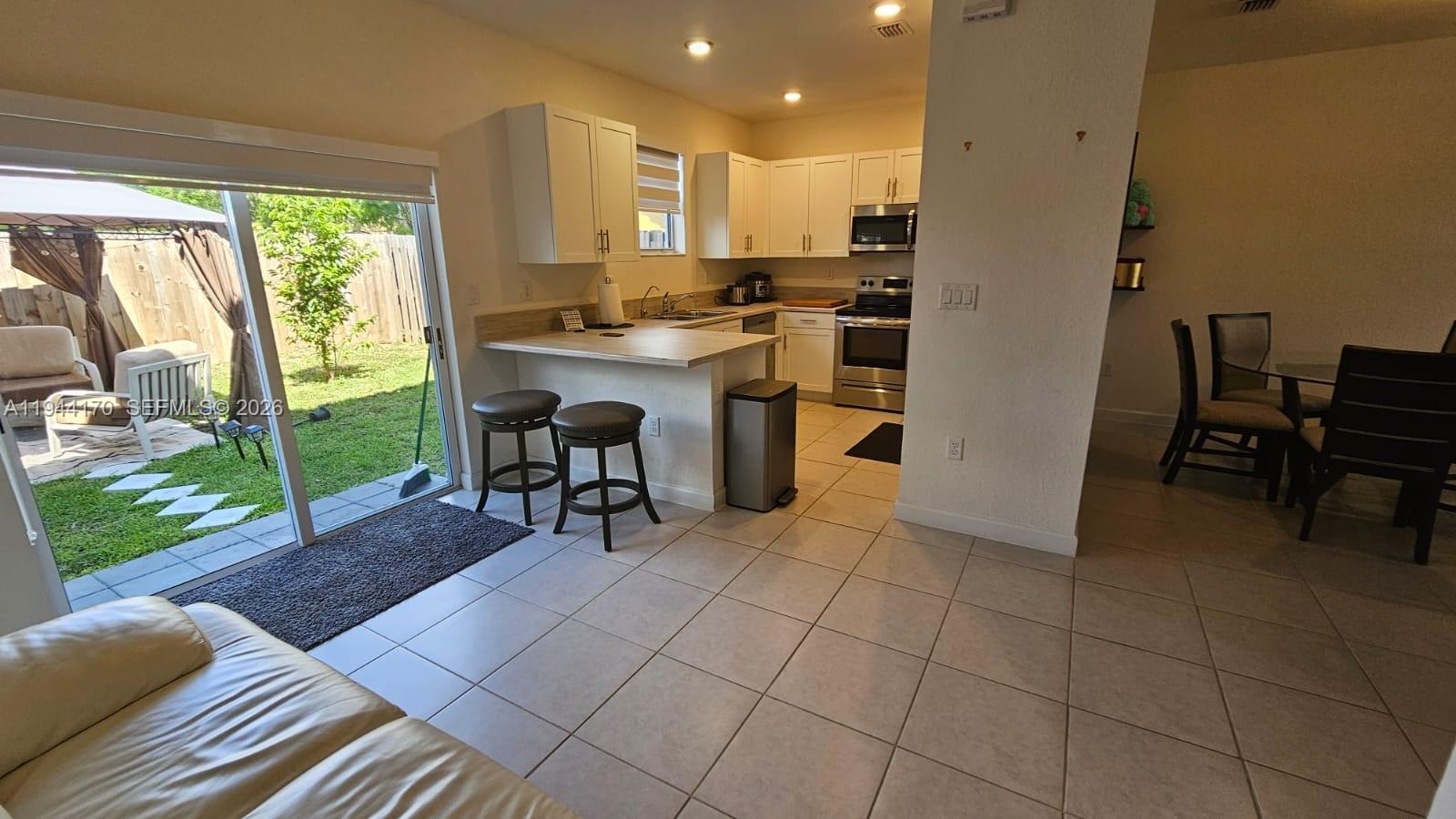 1146 Southeast 26th Street Homestead, FL 33035 - Photo 10 of 42 a open kitchen with a sink dining table and chairs