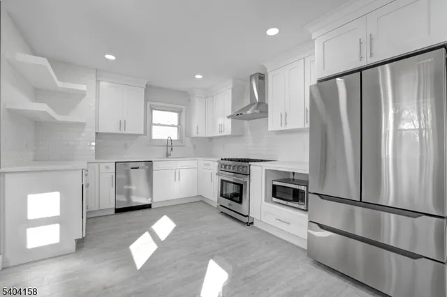 a kitchen with stainless steel appliances a refrigerator sink and cabinets
