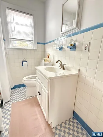 a bathroom with a sink a toilet and a mirror
