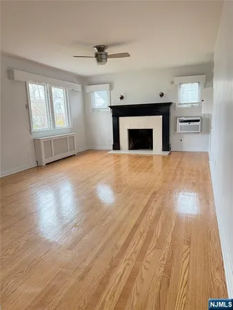 a view of empty room with wooden floor and fireplace