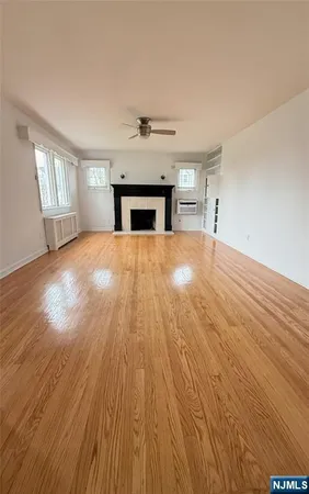 wooden floor fireplace and windows in an empty room