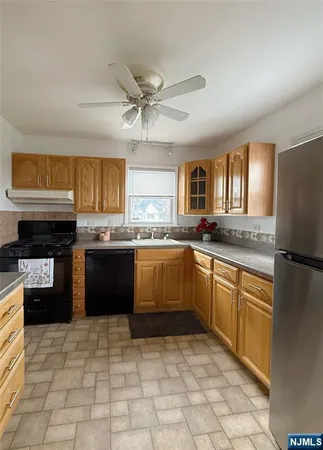 a kitchen with stainless steel appliances granite countertop a refrigerator a stove top oven and a sink