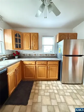 a kitchen with granite countertop a refrigerator and a stove top oven