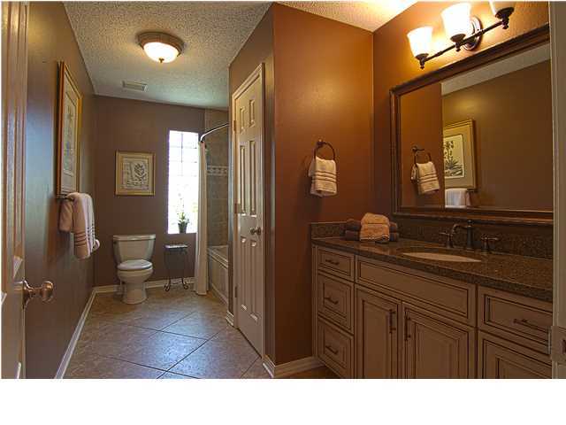 3927 Mesa Road Destin, FL 32541 - Photo 10 of 16 a bathroom with a sink a toilet and a large mirror