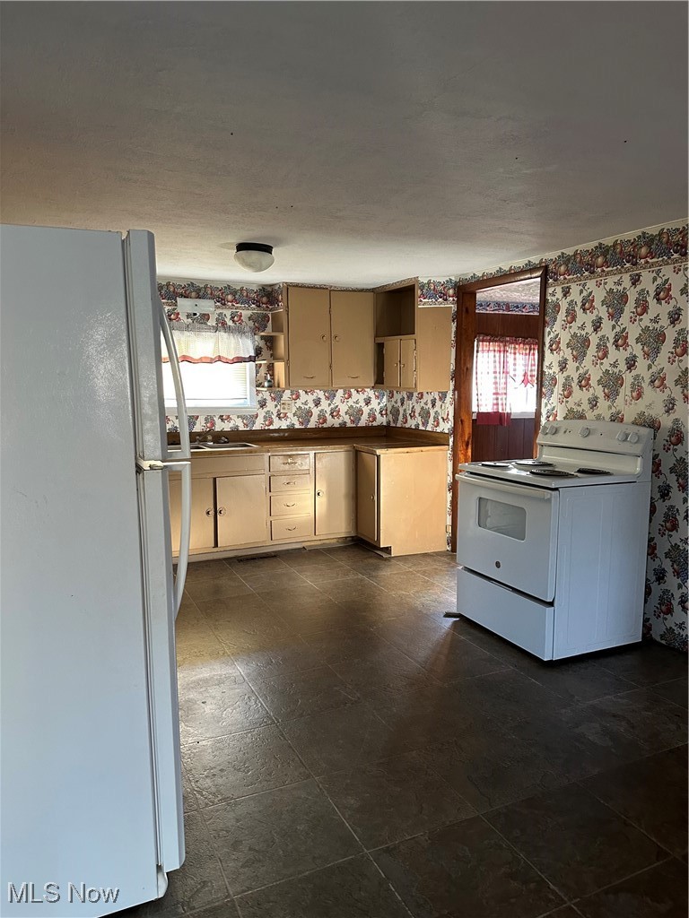 44952 Moose Ridge Road Woodsfield, OH 43793 - Photo 23 of 48 Kitchen featuring refrigerator, stove, wallpapered walls, dark countertops, and open shelves
