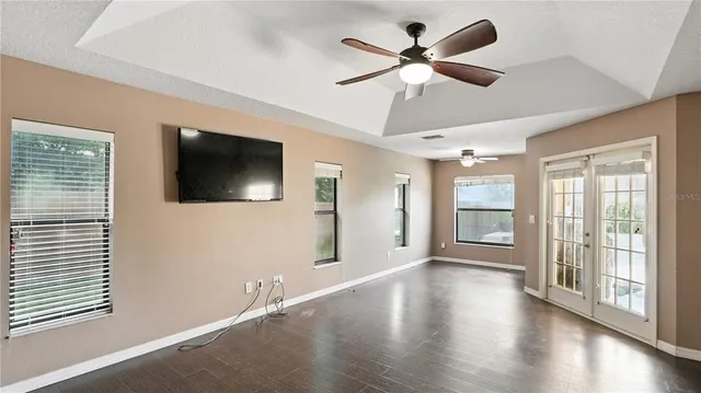 a view of an empty room with a window and wooden floor