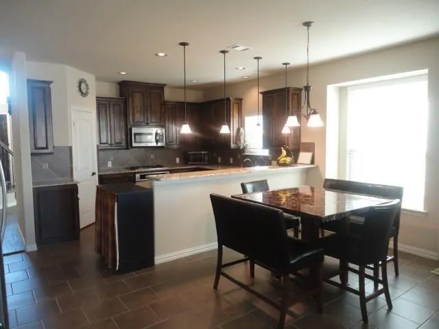 a kitchen with a sink a counter space appliances and cabinets