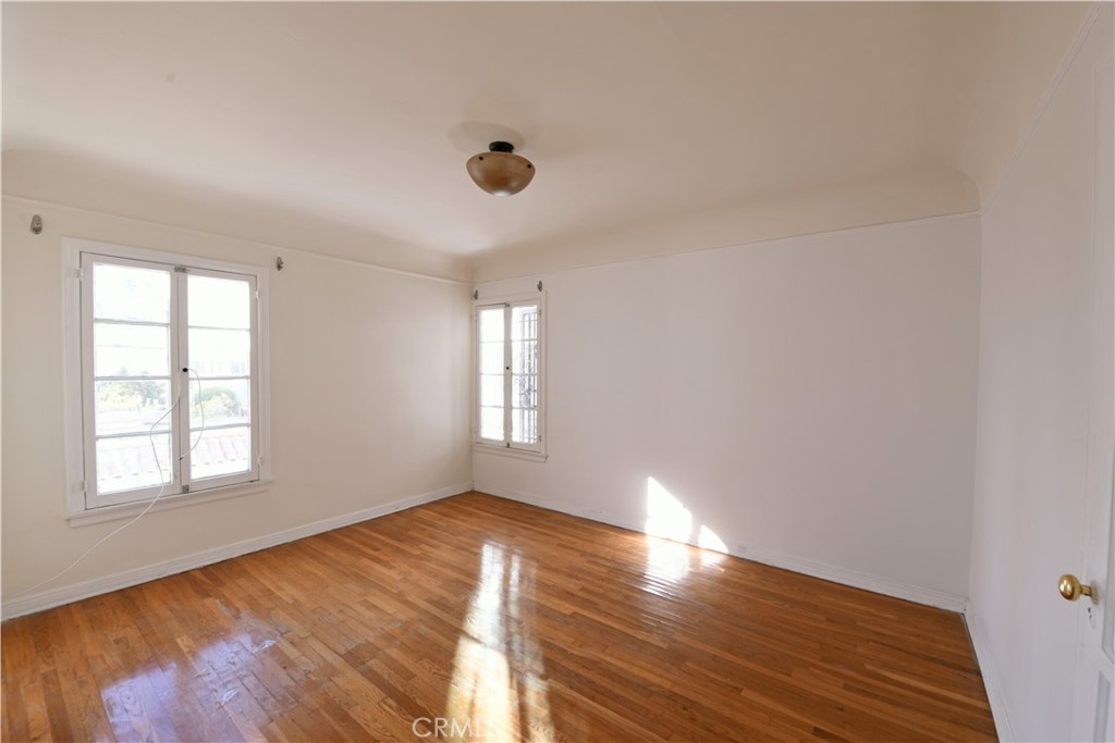 915 Le Doux Road Los Angeles, CA 90035 - Photo 12 of 30 an empty room with wooden floor and windows