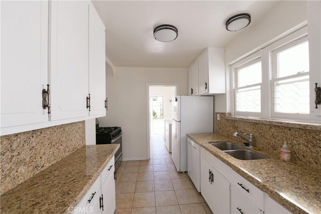 915 Le Doux Road Los Angeles, CA 90035 - Photo 8 of 30 a large kitchen with a granite countertop cabinets a sink a window and stainless steel appliances