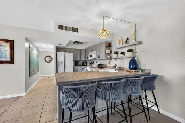 a kitchen with stainless steel appliances granite countertop a sink and a refrigerator