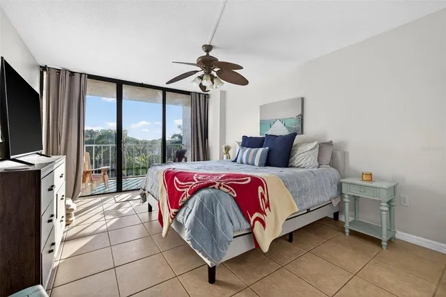 a spacious bedroom with a bed and a flat screen tv