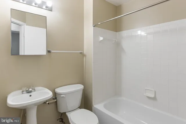 a bathroom with a sink toilet and a mirror