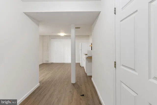 a view of a hallway with wooden floor and staircase