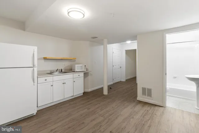 a kitchen with sink refrigerator and cabinets