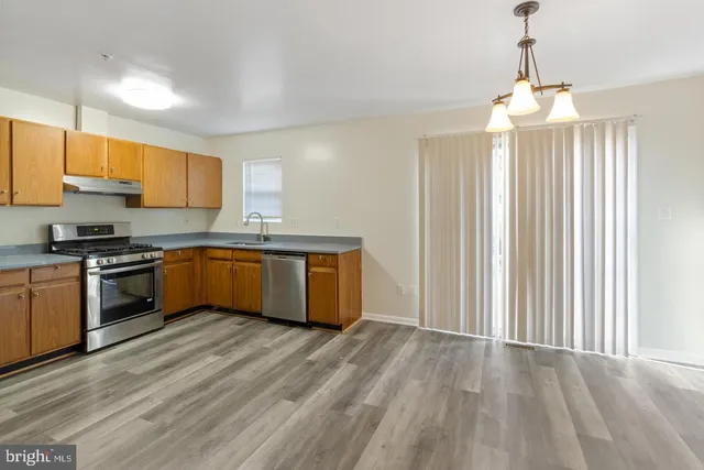 a kitchen with stainless steel appliances granite countertop a stove a sink dishwasher and a refrigerator