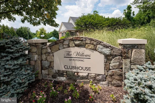 a sign board with a bench and trees
