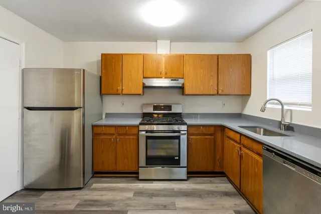 a kitchen with stainless steel appliances granite countertop a refrigerator stove and sink