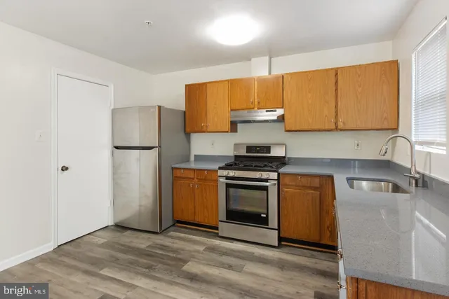 a kitchen with a sink a refrigerator and a stove top oven