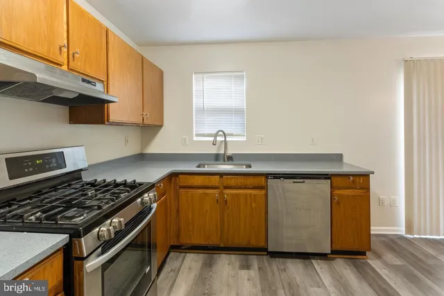 a kitchen with stainless steel appliances granite countertop a sink stove and cabinets