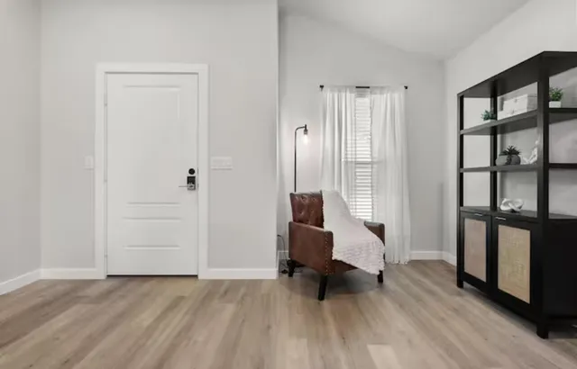 a view of a bedroom with wooden floor and furniture