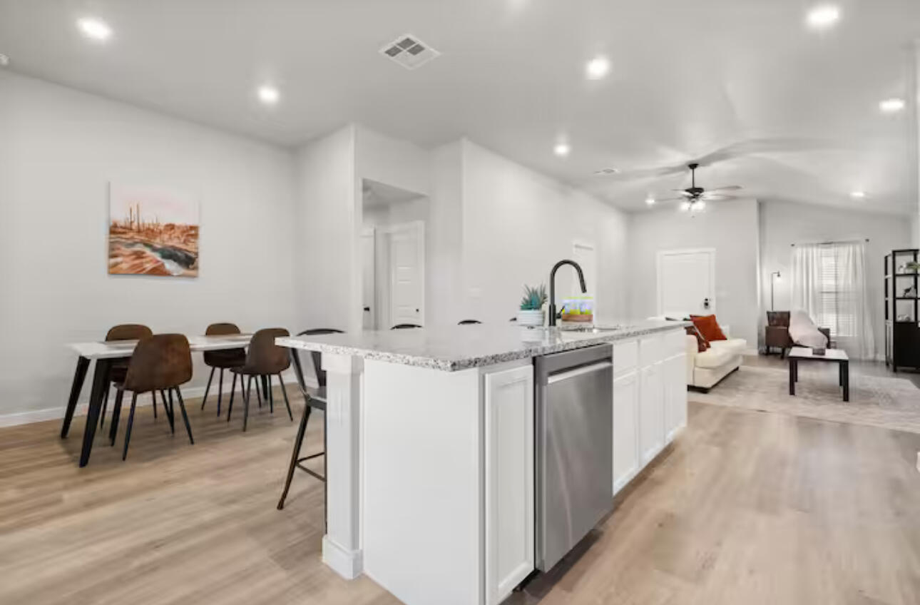 3518 Turner Avenue Lubbock, TX 79407 - Photo 5 of 12 a large white kitchen with kitchen island a sink table and chairs