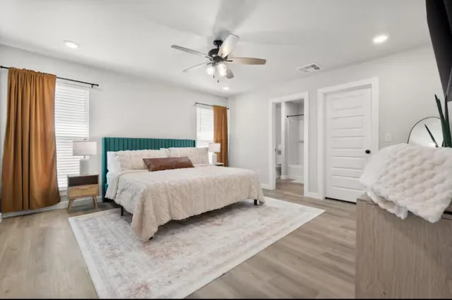 a bedroom with a large bed and a chandelier