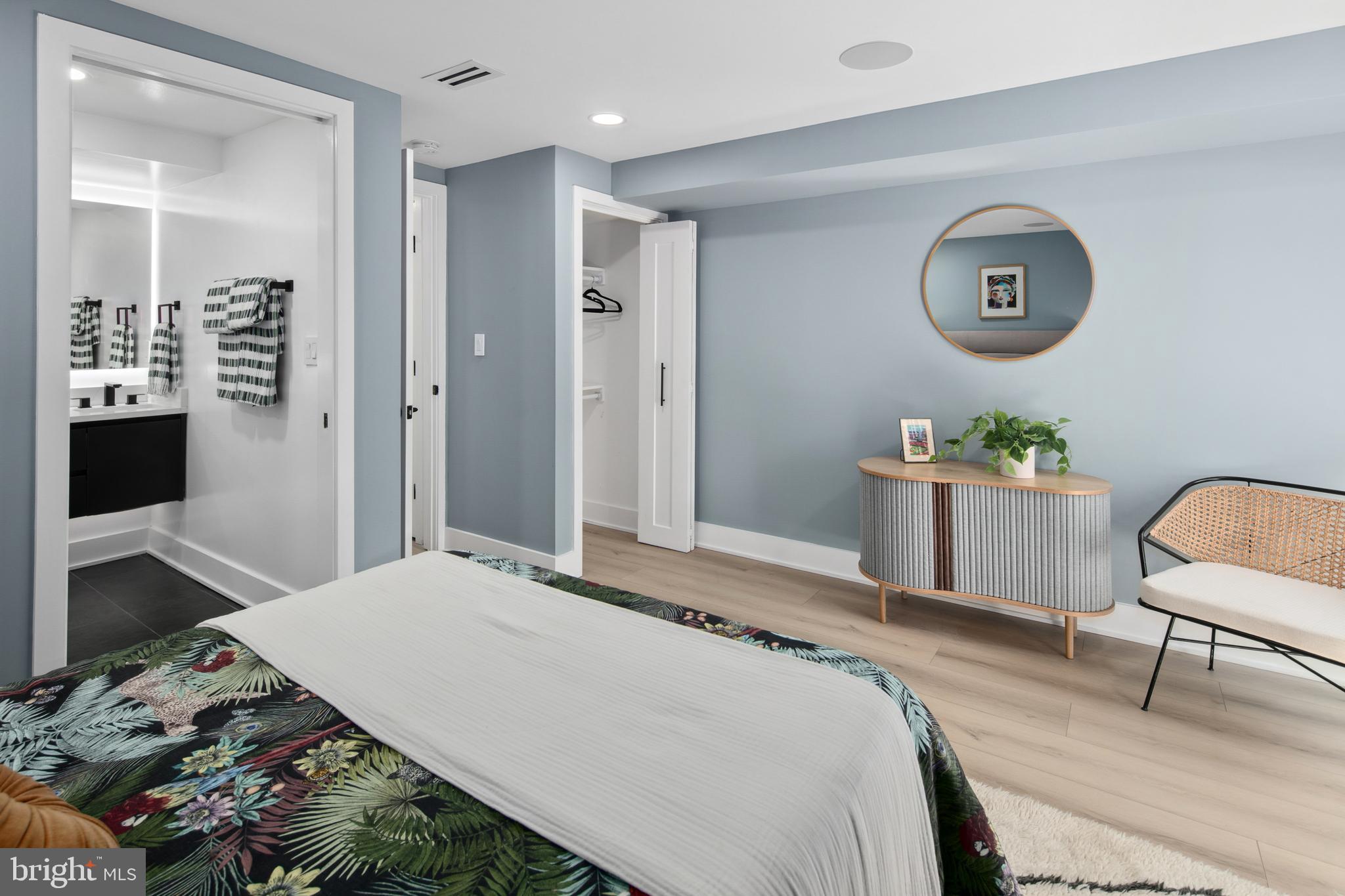 655 Morton Place Northeast, Unit 1 Washington, DC 20002 - Photo 15 of 26 a bedroom with a bed a chandelier a mirror and a lamp on table