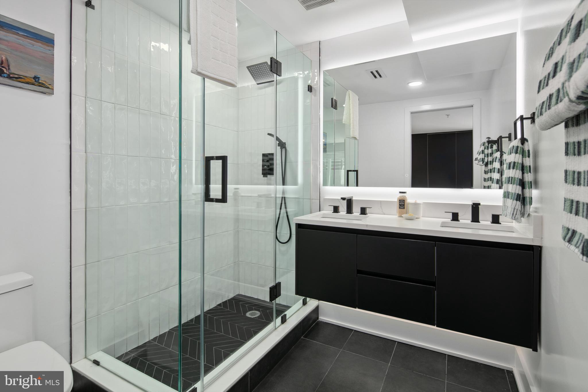 655 Morton Place Northeast, Unit 1 Washington, DC 20002 - Photo 16 of 26 a bathroom with a double vanity sink a toilet and shower