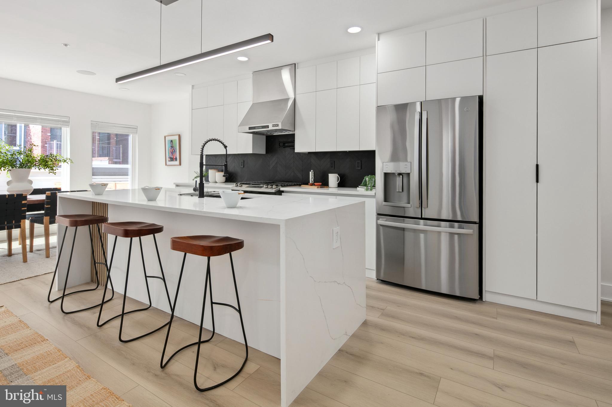 655 Morton Place Northeast, Unit 1 Washington, DC 20002 - Photo 5 of 26 a kitchen with stainless steel appliances a refrigerator a stove a sink and white cabinets