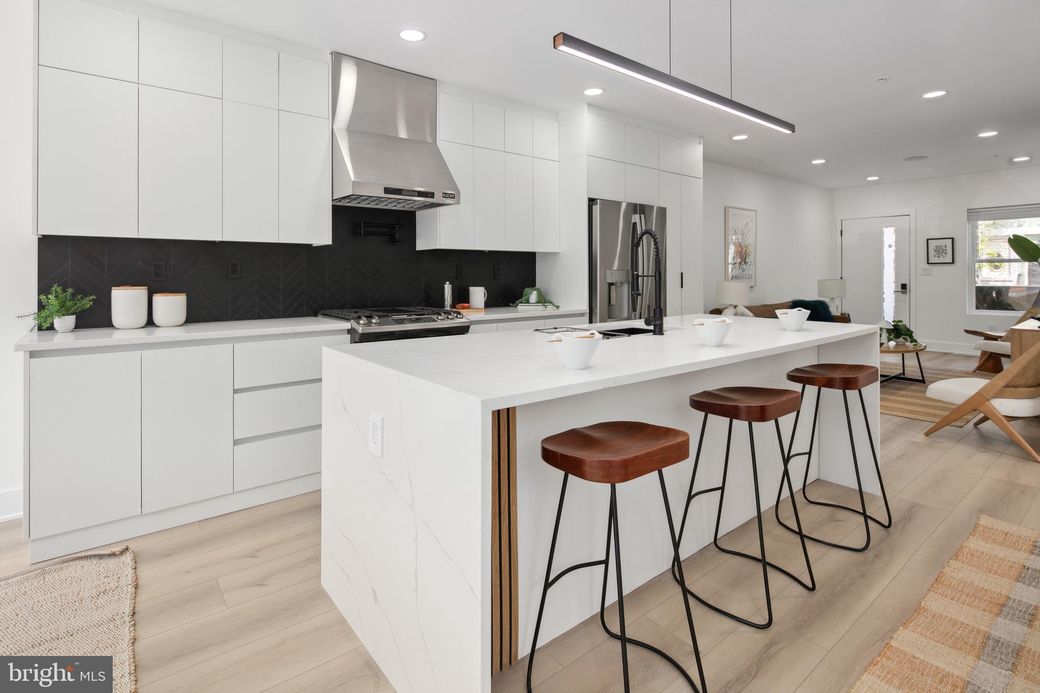 655 Morton Place Northeast, Unit 1 Washington, DC 20002 - Photo 6 of 26 a kitchen with stainless steel appliances kitchen island granite countertop a stove a sink and a refrigerator