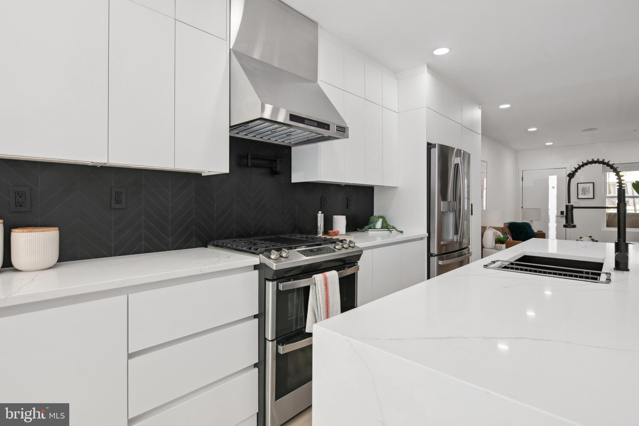 655 Morton Place Northeast, Unit 1 Washington, DC 20002 - Photo 7 of 26 a kitchen with stainless steel appliances a sink a stove a refrigerator and cabinets