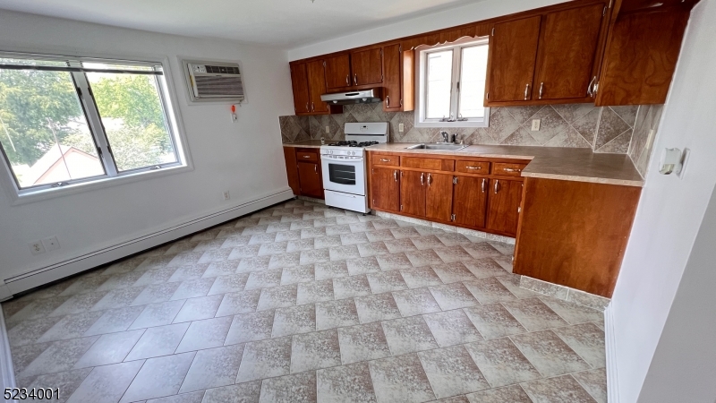 74 Mill Street Bloomfield, NJ 07003 - Photo 2 of 10 a kitchen with stainless steel appliances a sink a stove a refrigerator cabinets and a window