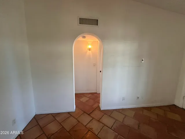 a view of a room with wooden floor and a white door