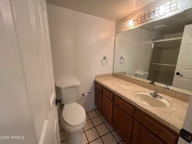 a bathroom with a granite countertop sink toilet and a mirror